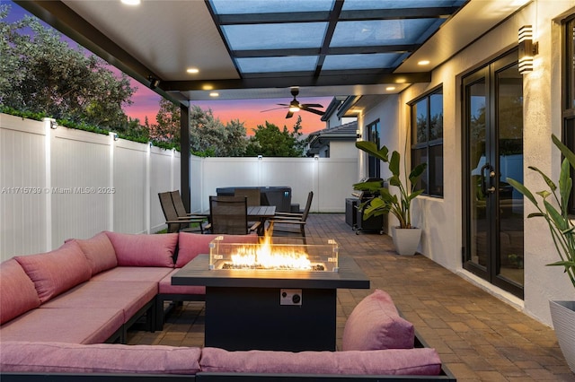 patio terrace at dusk featuring an outdoor living space with a fire pit