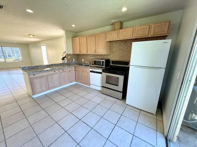 kitchen featuring kitchen peninsula, light brown cabinetry, backsplash, stainless steel appliances, and sink