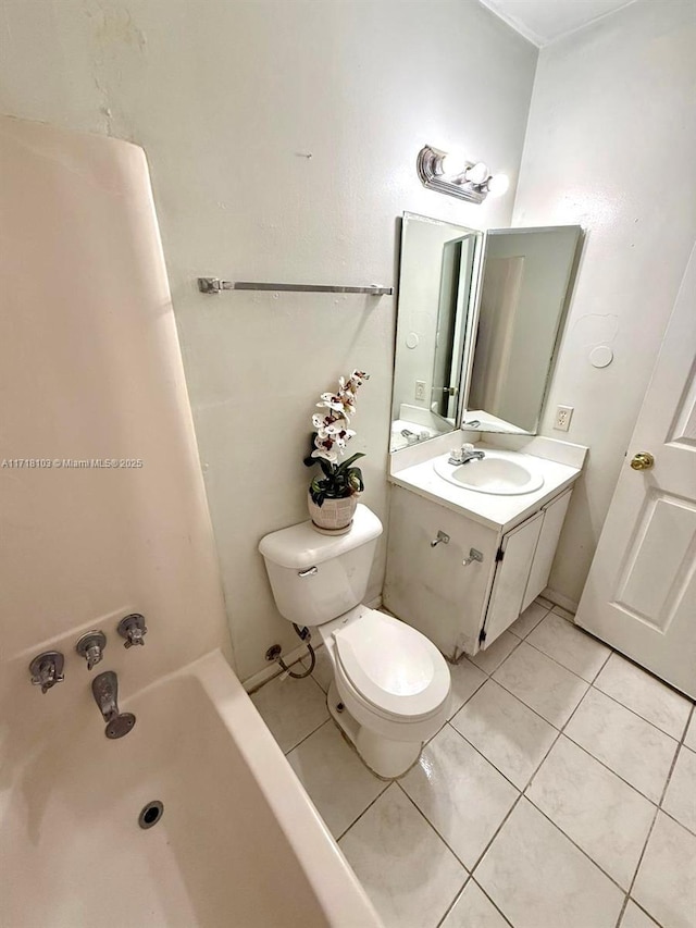 bathroom with toilet, vanity, a tub to relax in, and tile patterned floors