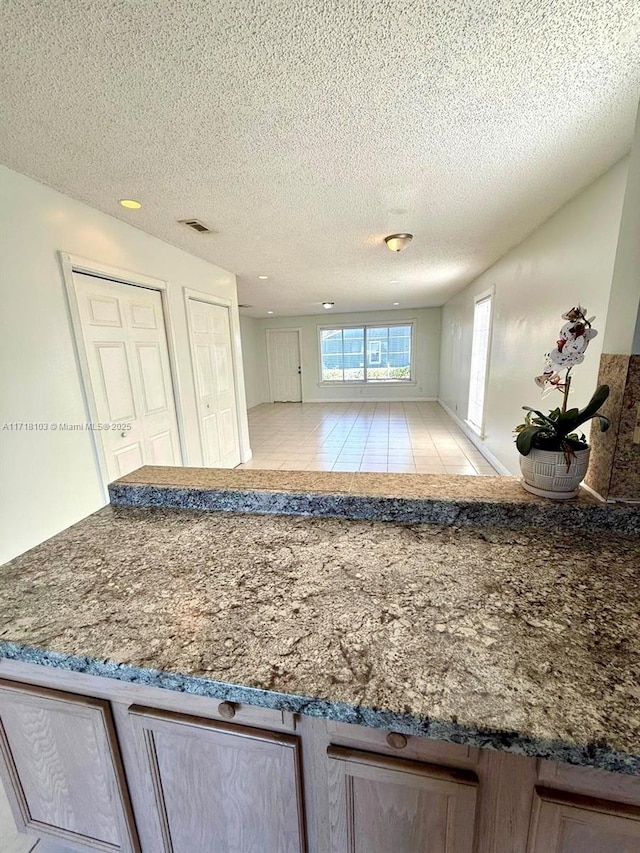 kitchen with a textured ceiling and light tile patterned flooring