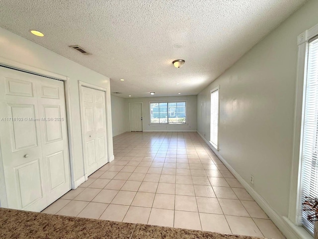 tiled spare room with a textured ceiling