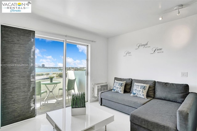 tiled living room featuring a wall mounted AC and a water view