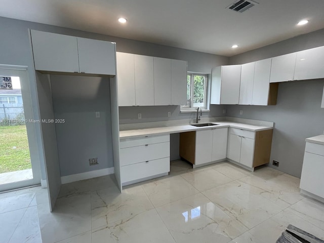 kitchen featuring white cabinets and sink