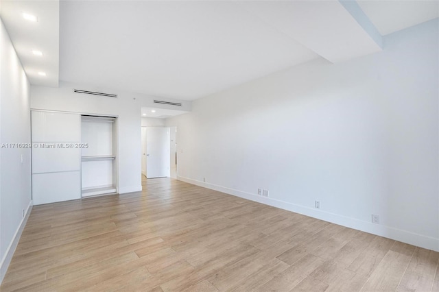 unfurnished bedroom featuring a closet and light wood-type flooring