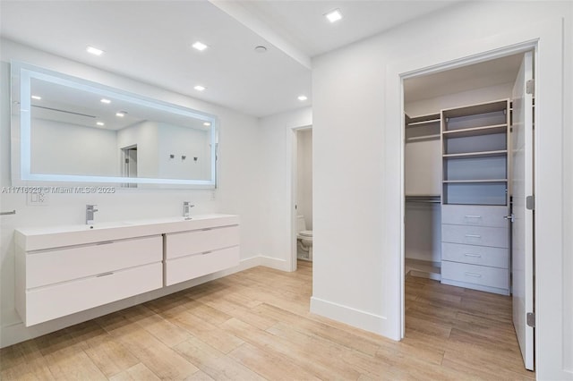 bathroom with vanity, toilet, and wood-type flooring