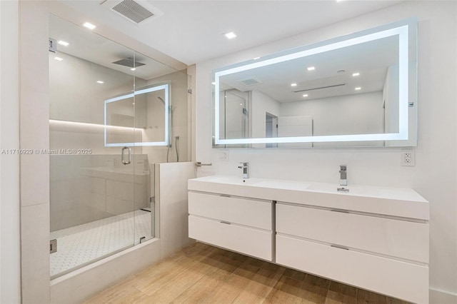 bathroom featuring wood-type flooring, vanity, and an enclosed shower