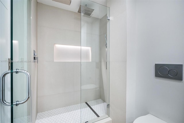 bathroom with toilet and a shower with shower door