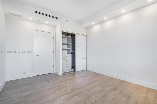 unfurnished bedroom with light hardwood / wood-style floors and a closet