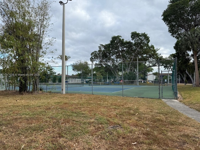 view of sport court featuring a lawn