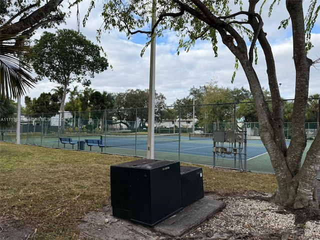 view of tennis court with a lawn