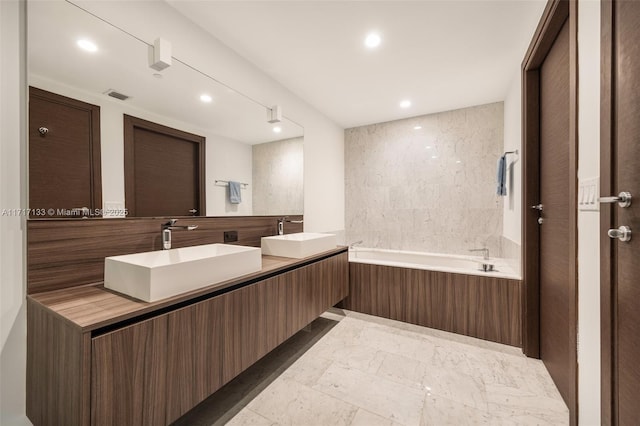 bathroom featuring vanity and a bath