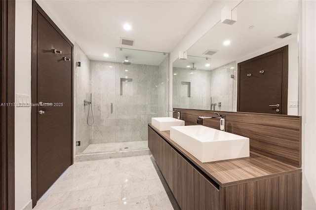 bathroom featuring an enclosed shower, vanity, and tile walls