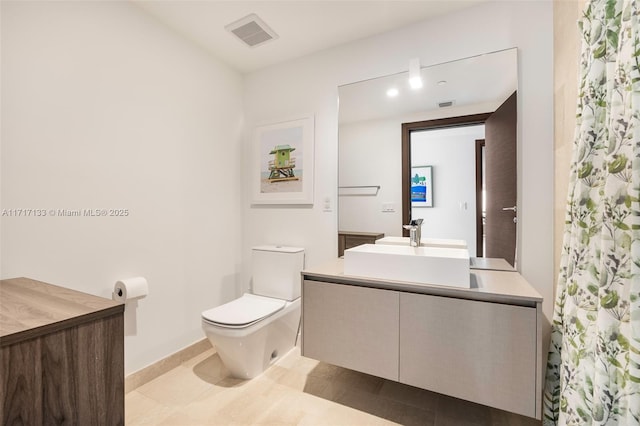 bathroom featuring tile patterned flooring, vanity, and toilet