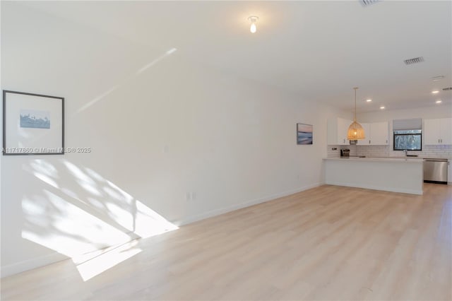 unfurnished living room with light wood-type flooring and sink