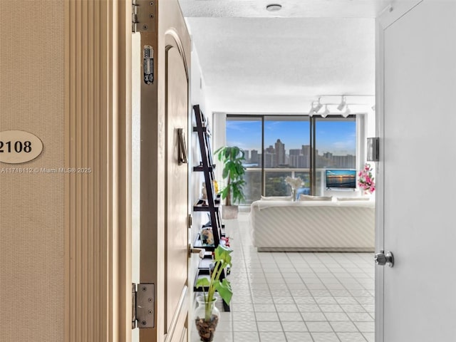 corridor featuring tile patterned flooring and a textured ceiling