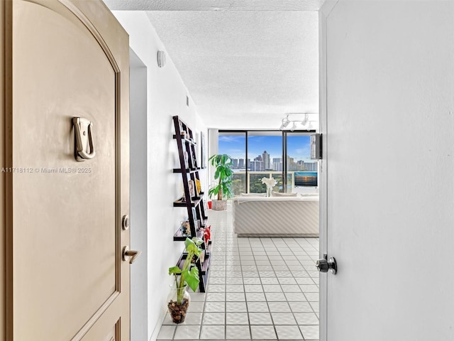 hall with light tile patterned floors and a textured ceiling