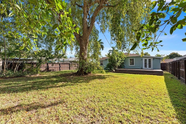 view of yard with a deck and french doors