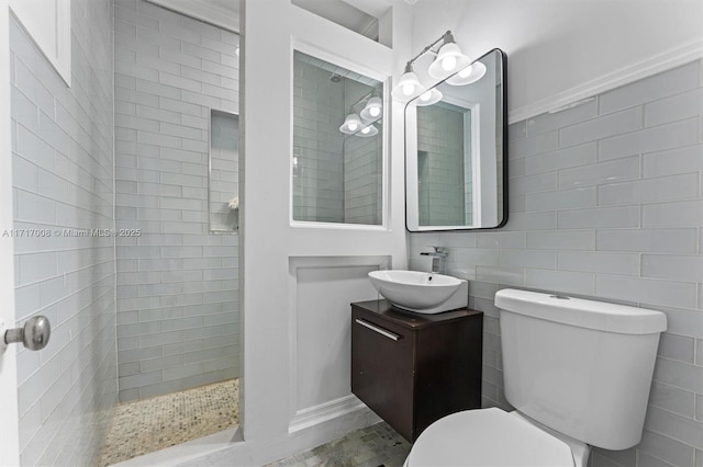 bathroom featuring tiled shower, vanity, and toilet