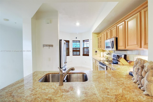 kitchen featuring light brown cabinets, sink, light stone countertops, and stainless steel appliances