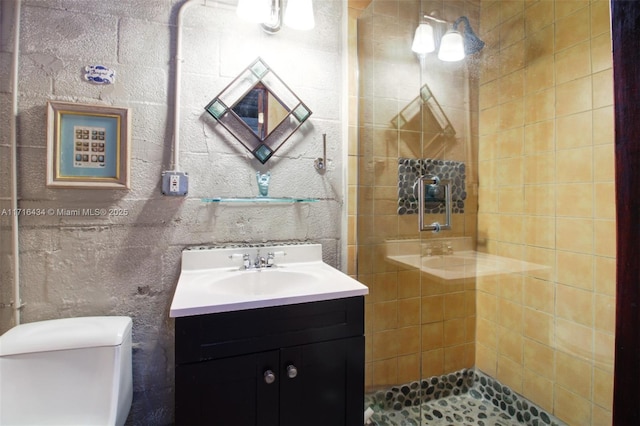 bathroom featuring vanity, toilet, and tiled shower