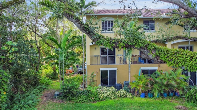 rear view of property with central AC