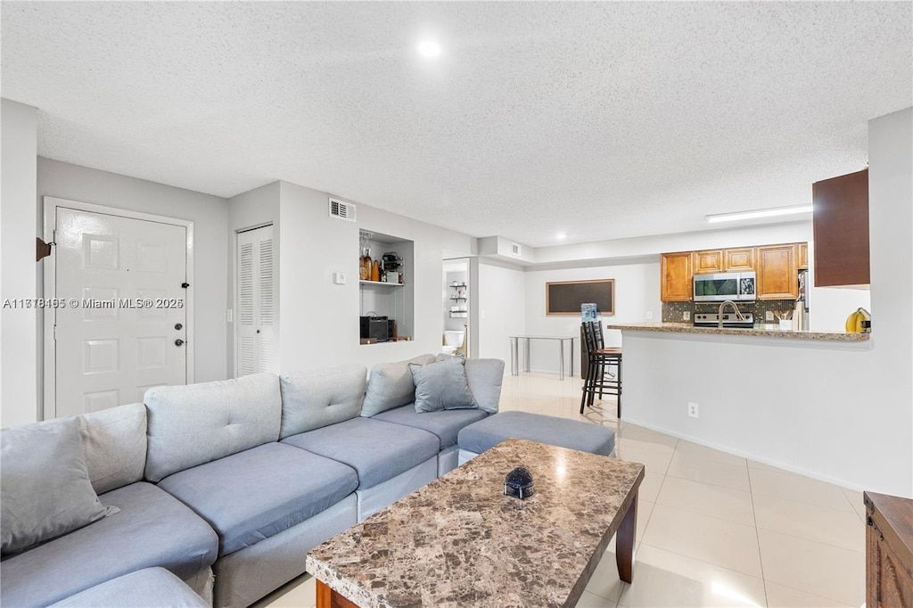 living room with light tile patterned floors and a textured ceiling