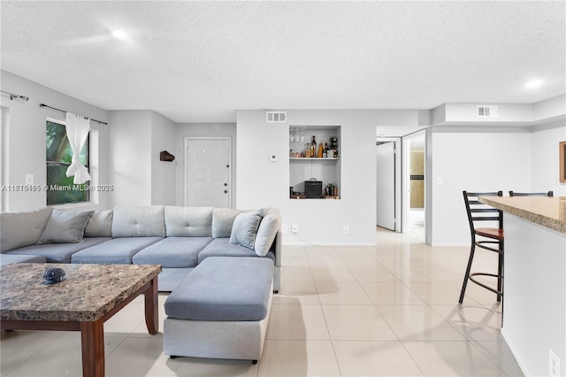 living room featuring light tile patterned floors and a textured ceiling