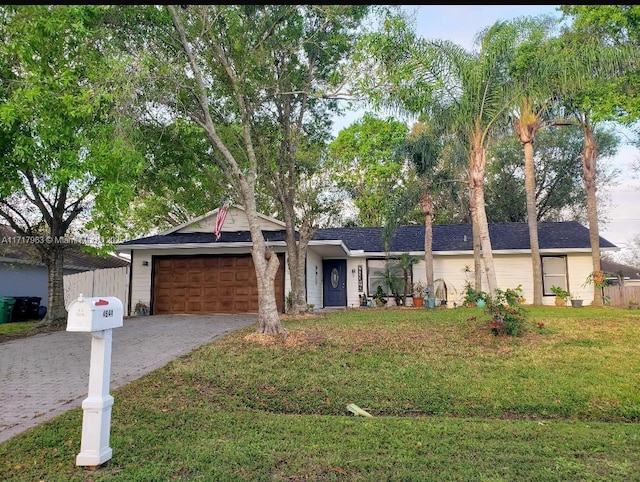 single story home featuring a garage and a front lawn