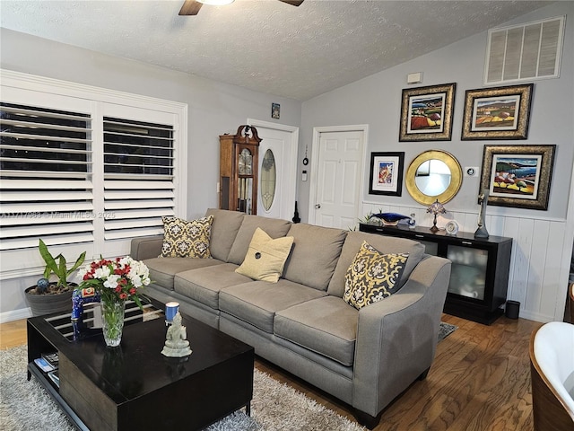 living room featuring dark hardwood / wood-style flooring, a textured ceiling, ceiling fan, and lofted ceiling