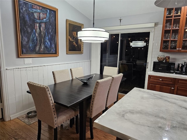 dining room with hardwood / wood-style flooring and lofted ceiling