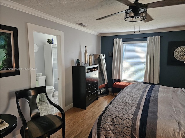 bedroom featuring ensuite bath, hardwood / wood-style flooring, ceiling fan, ornamental molding, and a textured ceiling