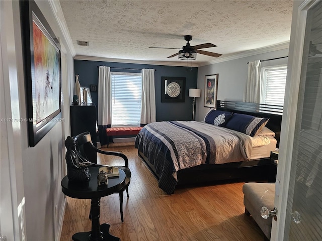 bedroom with ceiling fan, crown molding, and a textured ceiling