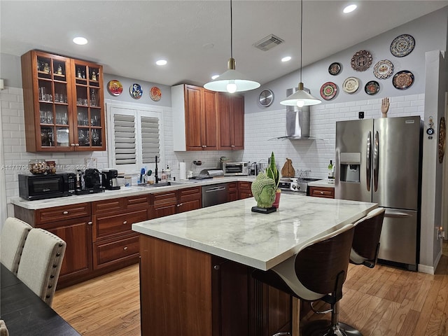 kitchen featuring sink, a center island, tasteful backsplash, decorative light fixtures, and appliances with stainless steel finishes