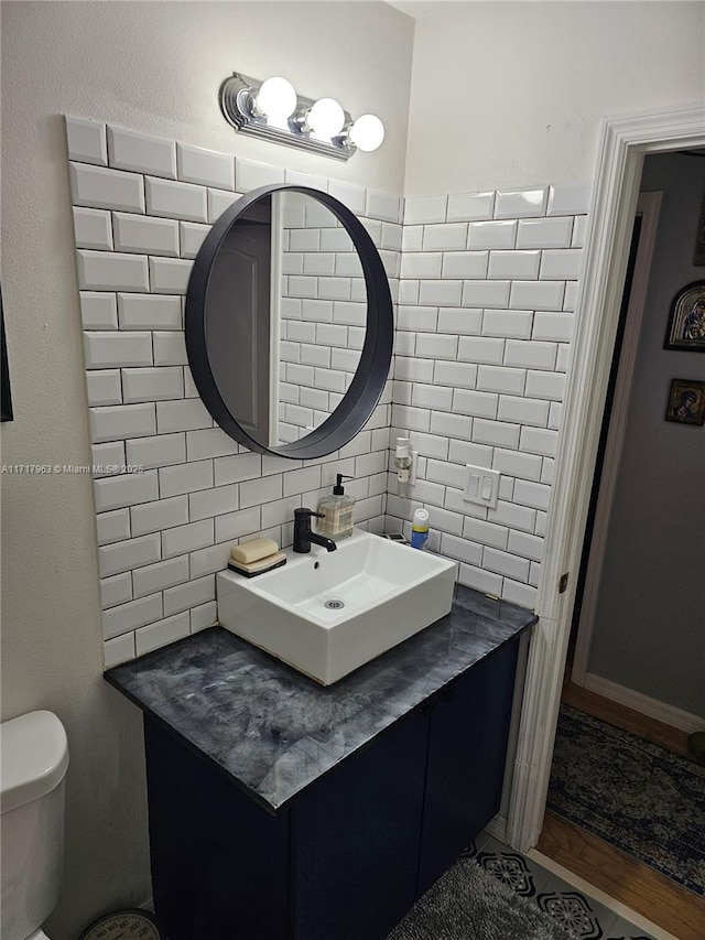 bathroom with decorative backsplash, vanity, and toilet