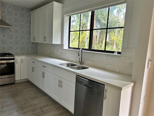 kitchen with stainless steel appliances, sink, decorative backsplash, and white cabinets