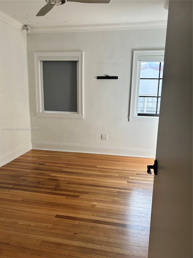 spare room with hardwood / wood-style floors, crown molding, and ceiling fan