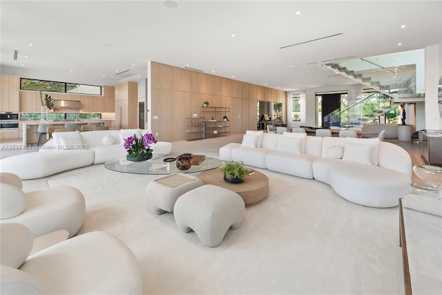 carpeted living room featuring wooden walls