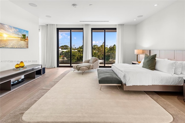 bedroom with multiple windows and light hardwood / wood-style flooring