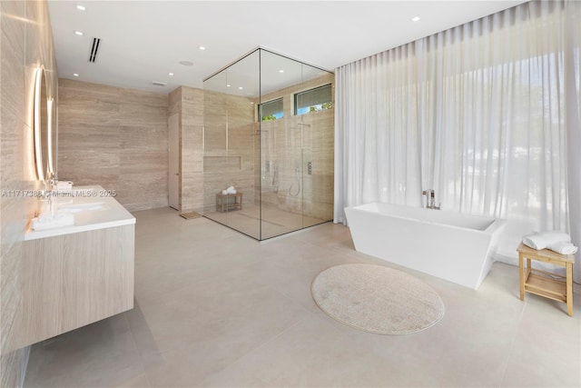 bathroom with tile patterned floors, vanity, and independent shower and bath