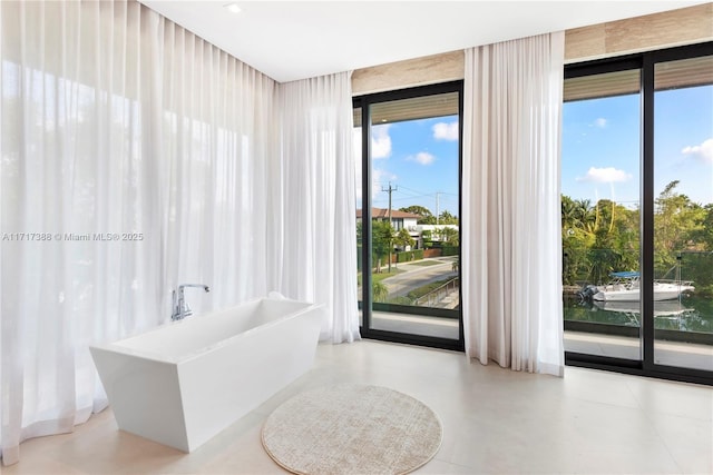 bathroom featuring a wealth of natural light, a bathtub, and expansive windows