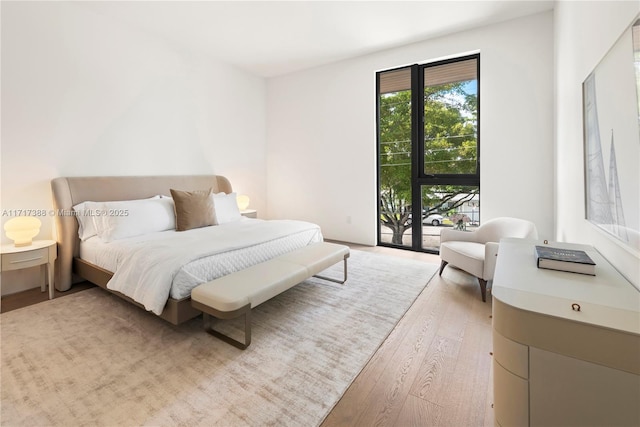 bedroom featuring wood-type flooring and access to outside