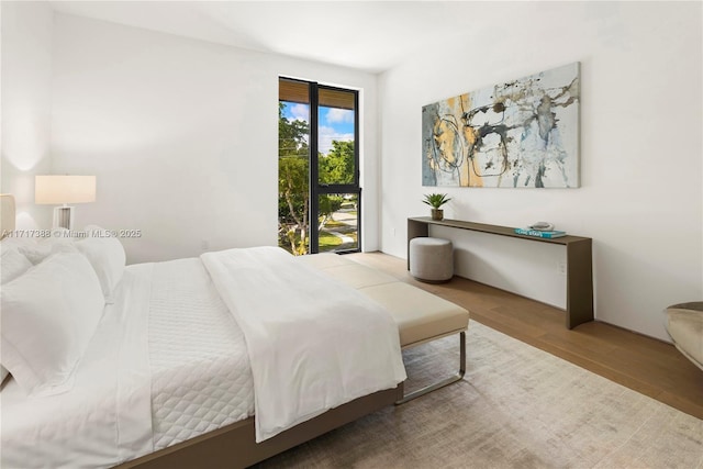 bedroom with access to outside and light hardwood / wood-style flooring