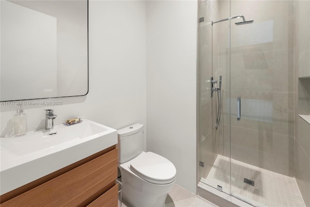 bathroom featuring vanity, toilet, and a shower with shower door