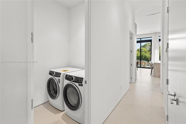 laundry area with separate washer and dryer and light tile patterned floors