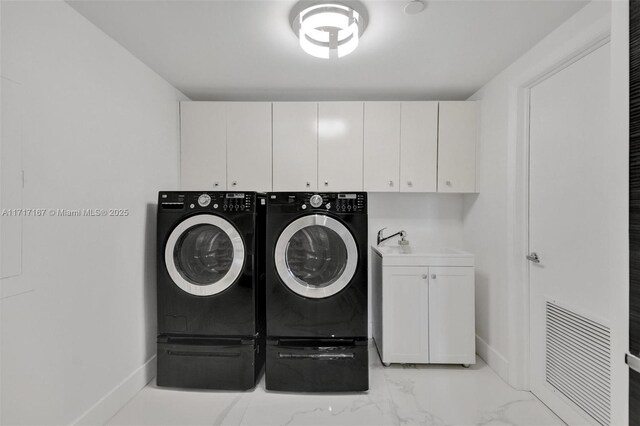 washroom featuring independent washer and dryer, cabinets, and sink