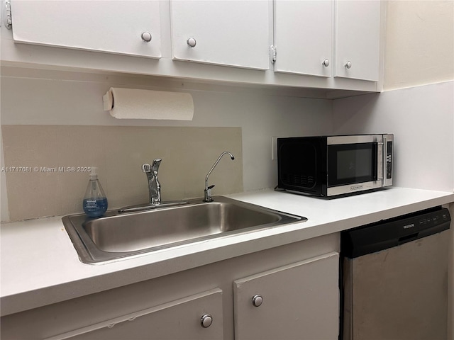 kitchen featuring appliances with stainless steel finishes, white cabinetry, and sink