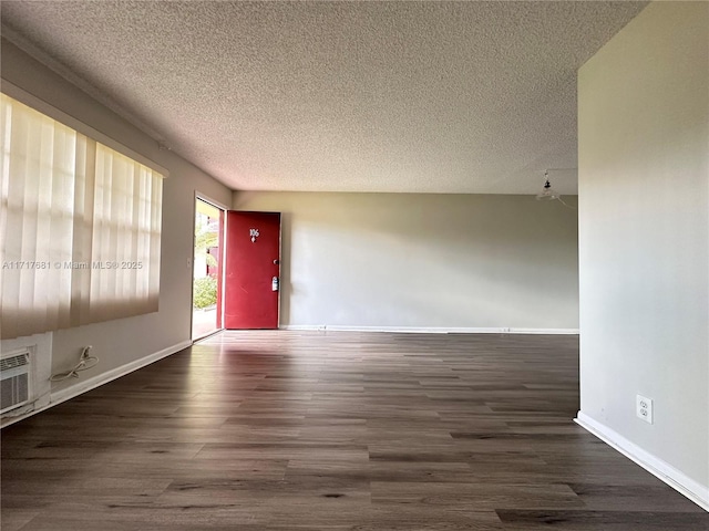 interior space featuring baseboards, a textured ceiling, and wood finished floors