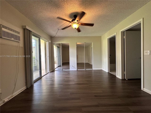 unfurnished bedroom with a wall mounted AC, a textured ceiling, and wood finished floors