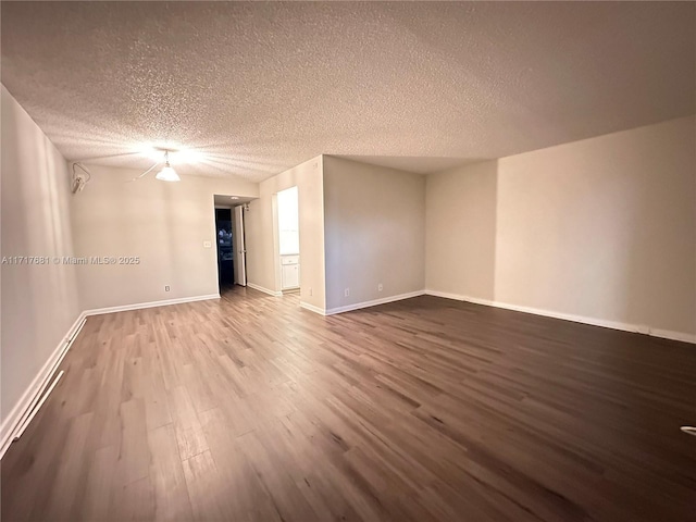 empty room featuring a textured ceiling and hardwood / wood-style flooring