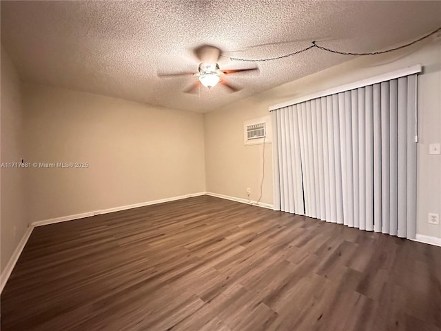 empty room with ceiling fan, a wall mounted air conditioner, a textured ceiling, and hardwood / wood-style flooring